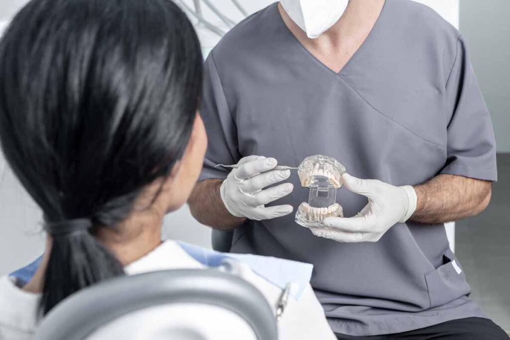 Dentist showing an opened dental mould to a patient in a dental clinic