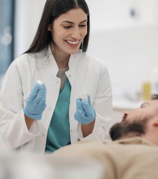 Female dentist showing teeth molds to patient in clinic