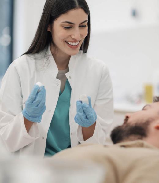 Female dentist showing teeth molds to patient in clinic